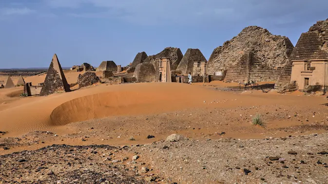 Seorang pengunjung berjalan diantara piramida Meroe di situs arkeologi Meroe di Bejrawiya, Sudan, Sabtu, 1 Agustus 2026. (Foto AP/Mohnd Blal)