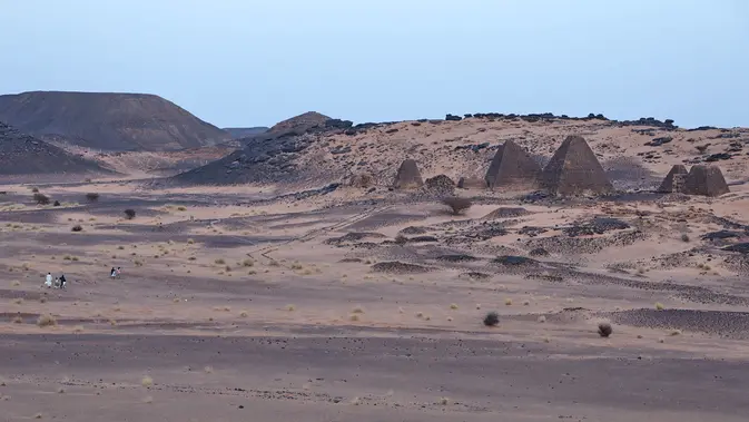 Pengunjung berjalan menuju Piramida Meroe di situs arkeologi Meroe di Bejrawiya, Sudan, Sabtu, 1 Agustus 2026. (Foto AP/Mohnd Blal)