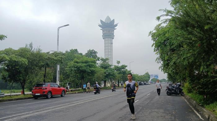 MENARA TERATAI - Warga berolahraga di Jalan Bung Karno Purwokerto berlatar Menara Teratai, Kamis (5/2/2026). Jalan Bung Karno Purwokerto menjadi satu di antara tempat favorit warga melakukan olahraga pagi.