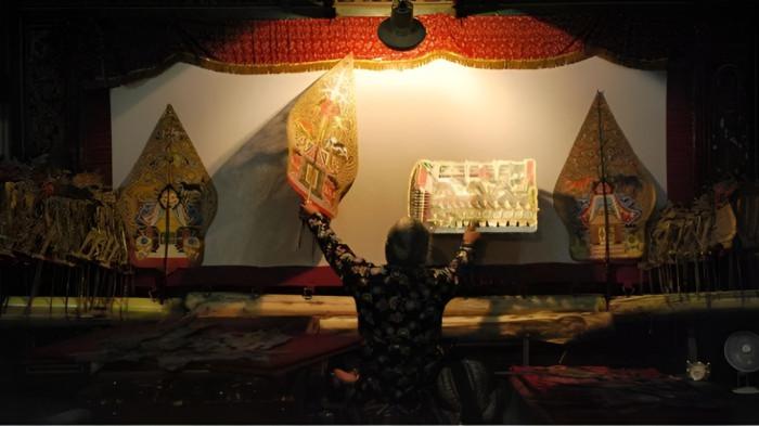 WAYANG KULIT- Ilustrasi seorang dalang saat menunjukkan kebolehannya dalam pementasan wayang kulit.