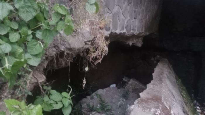 JEBOL - Tembok penahan saluran irigasi yang berada di Kampung Babakan Sirnarasa, Kelurahan Empangsari, Kecamatan Tawang Kota Tasikmalaya mengalami kerusakan parah dan berisiko ambruk, Minggu (9/8/2026). Bahkan warga minta dinas terkait segera memperbaiki.