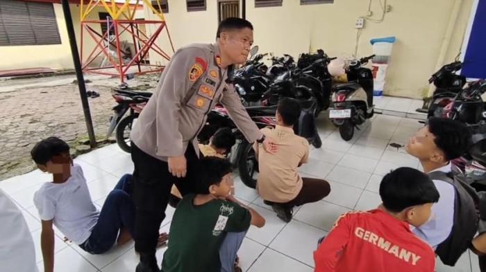 TAWURAN - Kapolsek Deli Tua, AKP Kenedy Sitompul ketika menginterogasi pelajar yang diamankan karena diduga hendak tawuran dengan siswa SMA Harapan Mandiri, Jumat (7/8/2026). Dari penangkapan 14 pelajar ditemukan pentungan baseball dan anak panah runcing berbahan besi.