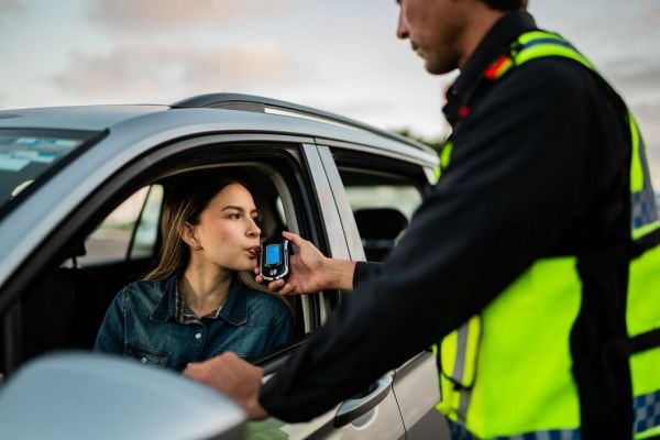 Young woman doing driver alcohol test on street Young woman doing driver alcohol test on street