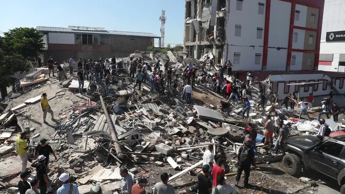 Warga dan petugas penyelamat mencari di antara reruntuhan bangunan yang runtuh setelah gempa bumi melanda Cali, Kolombia, Senin, 10 Agustus 2026. (AP Photo/Santiago Saldarriaga)