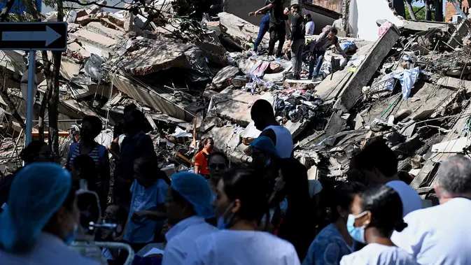 Sejumlah orang mencari korban yang tertimbun  bangunan yang runtuh akibat gempa bumi di Cali, Kolombia, Senin, 10 Agustus 2026 (AFP/ Joaquin Sarmiento)
