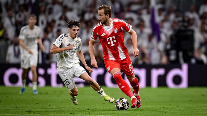 BERDUEL - Penyerang Bayern Munchen, Harry Kane (kanan) saat mendapatkan penjagaan dari pemain Real Madrid, Thiago Pitarch Pinar (kiri) pada pertandingan leg pertama Perempat Final Liga Champions 2025/2026 di Santiago Bernabeu, Spanyol, Rabu (8/4) dini hari WIB.