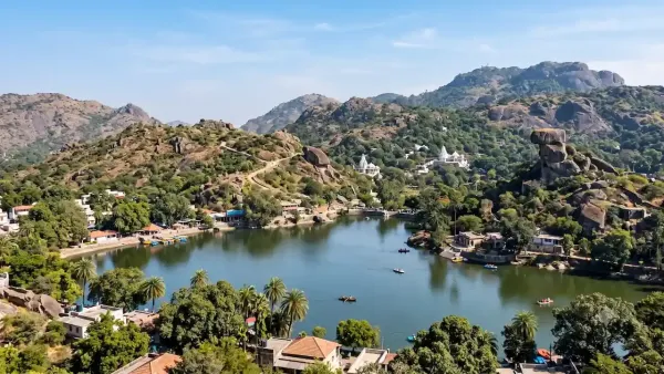Scenic view of Nakki Lake in Mount Abu surrounded by rocky hills green trees and famous Toad Rock.