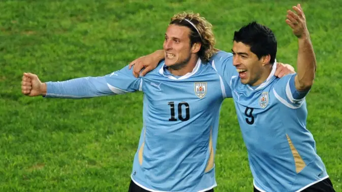 Penyerang Timnas Uruguay Luis Suarez (kanan) dan Diego Forlan merayakan gol ke gawang Peru dalam pertandingan semifinal Copa America 2011 di Stadion Ciudad de La Plata, La Plata—sekitar 59 km di selatan Buenos Aires—pada 19 Juli 2011. Uruguay menang 2-0 dan melaju ke babak final. (Maxi Failla/AFP)