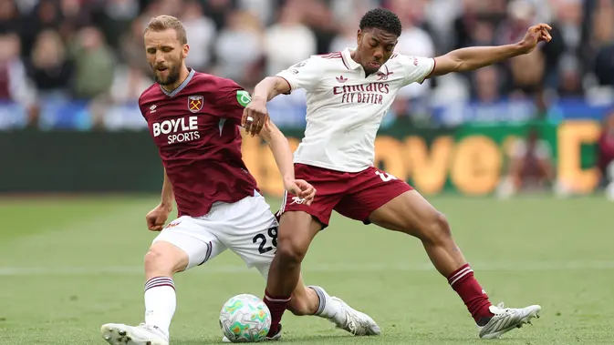 Pemain West Ham United, Tomas Soucek (kiri), berebut bola dengan pemain Arsenal, Myles Lewis-Skelly, dalam pertandingan Liga Inggris di London Stadium, Inggris, Minggu (10/5/2026) malam WIB. (AP Photo/Ian Walton)