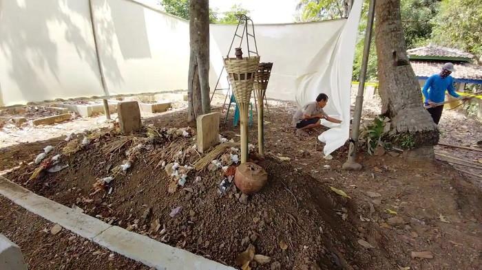 EKSHUMASI MAKAM - Suasana makam Sutrimo jelang ekshumasi di TPU Bantaragung, Desa Wlahar, Kecamatan Wangon, Kabupaten Banyumas, Selasa (11/8/2026). Bagi Sanardo (65), mendirikan tenda di area pemakaman sebenarnya bukan pekerjaan yang biasa dilakukan.