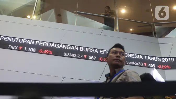 Pengunjung melintas dilayar pergerakan saham di BEI, Jakarta. (Liputan6.com/Angga Yuniar)