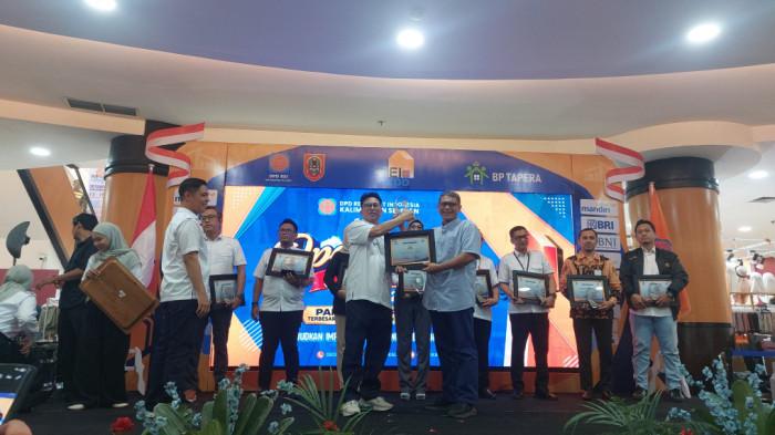 Direktur Banjarmasin Post, Wahyu Indryanta, menerima plakat dan piagam sebagai media partner