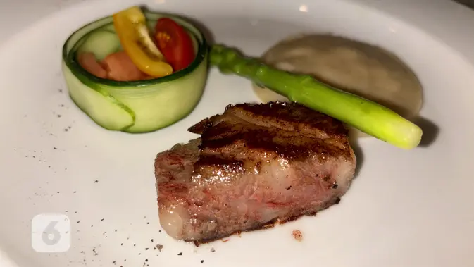 Main course pertama berupa striploin beef fingers yang disajikan dengan mashed cassave khas Nusa Tenggara Timur, asparagus, dan heirloom tomatoes di jamuan makan siang eksklusif yang digelar Arita Wagyu Farm dari Miyazaki bersama Alpha Agro Indonesia di Tugu Kunstkring Paleis, Jakarta, 6 Agustus 2026. (Liputan6.com/Asnida Riani)