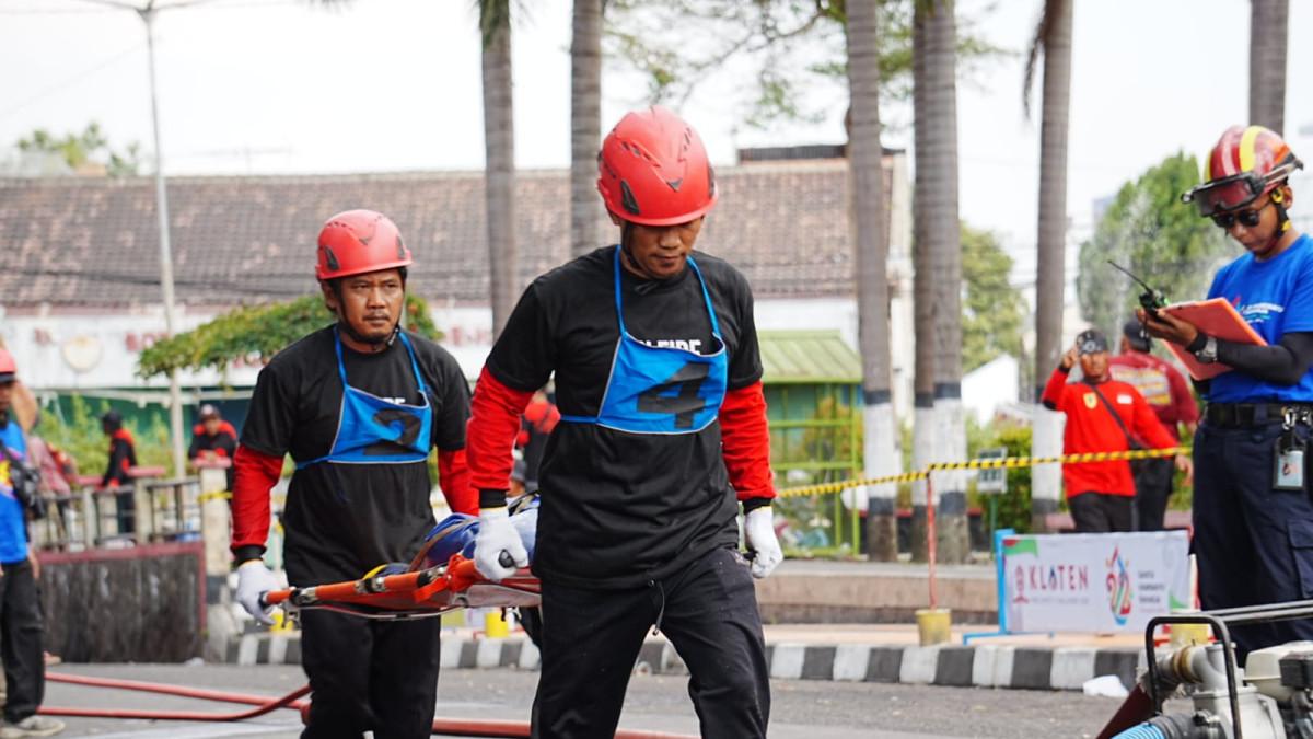 EVENT DI KLATEN - Peserta Klaten Fire Safety Challenge 2026 melakukan simulasi evakuasi korban menggunakan tandu di Alun-Alun Klaten, Selasa (11/8/2026).