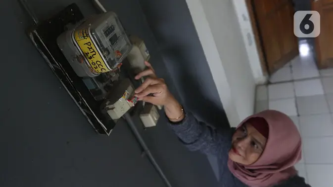 Warga memeriksa meteran listrik di kawasan Matraman, Jakarta, Kamis (2/4/2020). Di tengah pandemi COVID-19, pemerintah menggratiskan biaya tarif listrik bagi konsumen 450 Volt Ampere (VA) dan pemberian keringanan tagihan 50 persen kepada konsumen bersubsidi 900 VA. (Liputan6.com/Herman Zakharia)