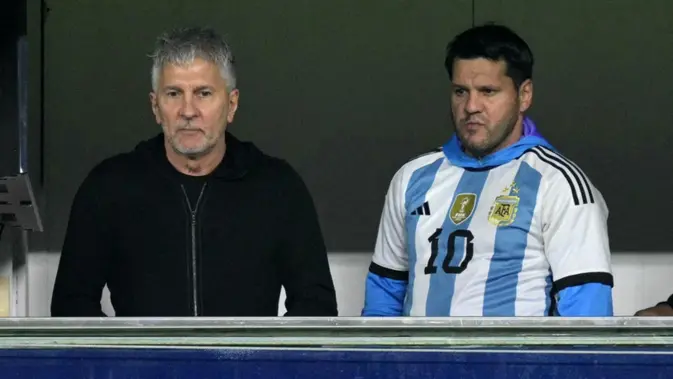 Ayah penyerang Argentina Lionel Messi, Jorge Messi (kiri), dan saudaranya, Rodrigo, menunggu dimulainya pertandingan kualifikasi Piala Dunia 2026 zona Amerika Selatan antara Argentina dan Peru di Stadion La Bombonera, Buenos Aires, pada 19 November 2024. (JUAN MABROMATA/AFP)