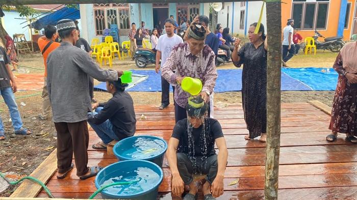 Abdul Hamid (78) memandikan peserta dalam prosesi Bejiu Safar atau Mandi Safar