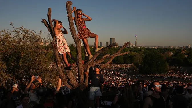 Warga menyaksikan gerhana matahari di Primrose Hill, London, Rabu, 12 Agustus 2026. (Foto AP/Kirsty Wigglesworth)