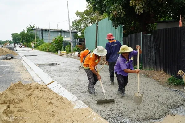 Workers construct sidewalks and roads along Tham Luong - Ben Cat - Nuoc Len canal, August 2026. Photo: Giang Anh