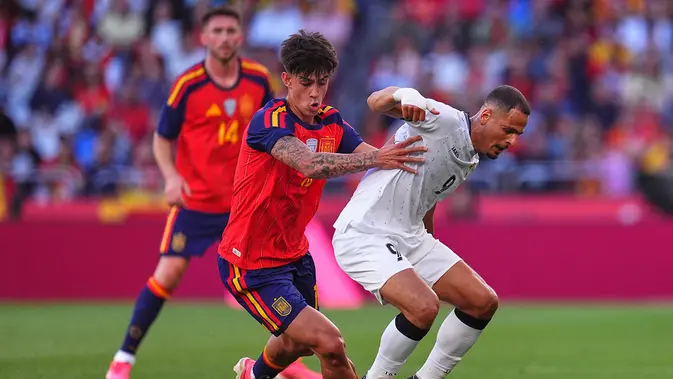 Marc Bernal dan Ali Al-Hamadi berduel memperebutkan bola dalam laga uji coba internasional antara Spanyol vs Irak di Estadio Abanca-Riazor, 5 Juni 2026. (AP Photo/Manu Fernandez)