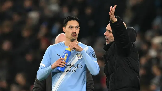 Manajer Manchester City, Pep Guardiola (kanan), berbicara dengan pemainnya, Tijjani Reijnders, saat laga Liga Inggris kontra Chelsea di Stadion Etihad, 4 Januari 2026. (Oli Scarff/AFP)