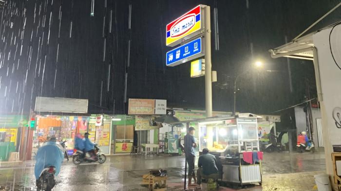 HUJAN SEDANG- Ilustrasi hujan sedang pada malam hari yang kemudian membasahi jalanan.