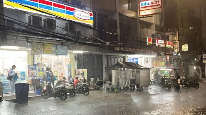 HUJAN LEBAT- Ilustrasi hujan lebat di malam hari yang menyebabkan jalanan tergenang air. Hari ini, Kamis 13 Agustus 2026, Kota Medan diperkirakan berpotensi dilanda hujan ringan.