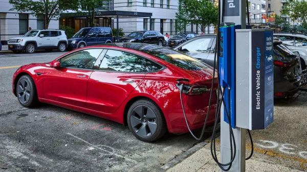 A Tesla Model 3 parked and using a public charger in New York City.