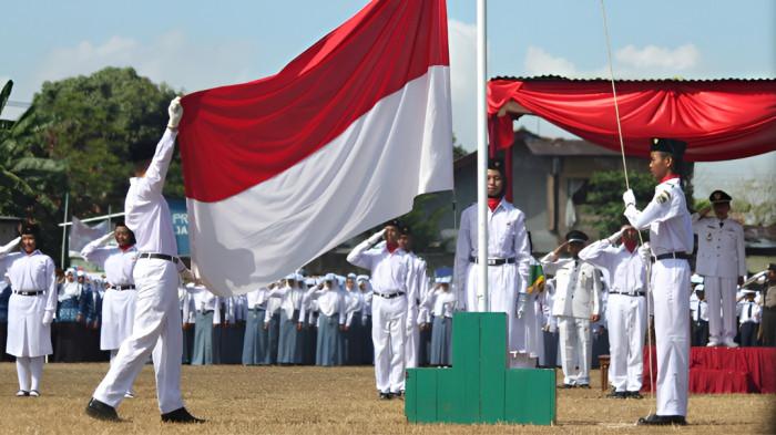 UPACARA BENDERA- Sejumlah siswa berseragam serba putih saat mengibarkan bendera merah putih pada momen upacara 17 Agustus. Upacara termasuk satu diantara tradisi 17 Agustus di Indonesia.
