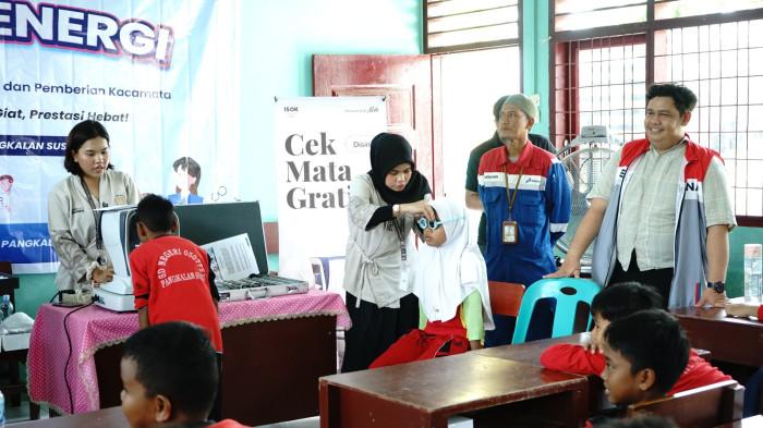 Perwira Pertamina EP Pangkalansusu mendampingi siswa dalam kegiatan pemeriksaan mata gratis melalui program Lensa Energi.