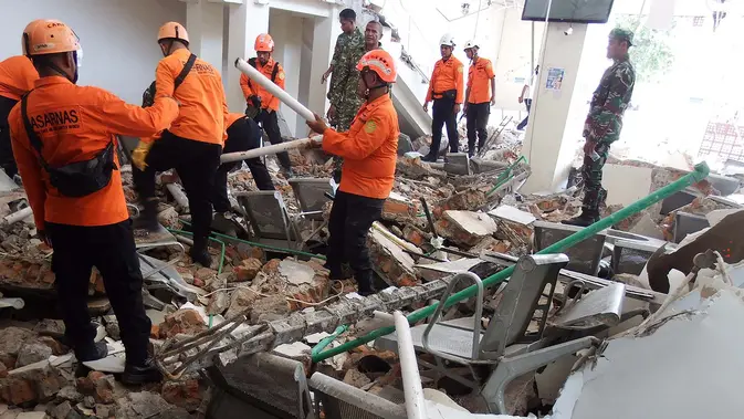 Tim penyelamat mencari korban di reruntuhan setelah gempa berkekuatan magnitudo 7,7 mengguncang Pulau Flores di  Pelabuhan Laurensius Say di Maumere, Sikka, Nusa Tenggara Timur, Sabtu, 15 Agustus 2026. (AFP/ Arnold Welianto)