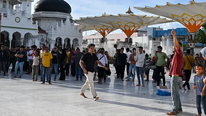 Peringatan 21 Tahun Perjanjian Damai Aceh Berujung Ricuh Para pengunjuk rasa yang marah meneriaki tentara saat mereka menurunkan bendera Gerakan Aceh Merdeka (GAM) yang dikibarkan berdampingan dengan bendera nasional Indonesia dalam sebuah unjuk rasa di Masjid Raya Baiturrahman, Banda Aceh, Sabtu, 15 September 2026. (AFP/ Chaideer Mahyuddin)