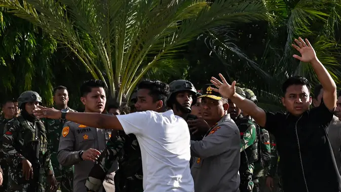 Peringatan 21 Tahun Perjanjian Damai Aceh Berujung Ricuh Para tentara berupaya menenangkan pengunjuk rasa yang marah saat mereka menurunkan bendera Gerakan Aceh Merdeka (GAM) yang dikibarkan berdampingan dengan bendera nasional Indonesia dalam sebuah unjuk rasa di Masjid Raya Baiturrahman, Banda Aceh, Sabtu, 15 September 2026. (AFP/ Chaideer Mahyuddin)
