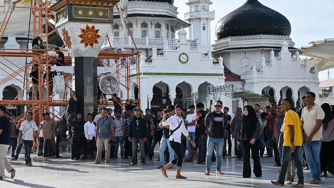 Peringatan 21 Tahun Perjanjian Damai Aceh Berujung Ricuh Para pengunjuk rasa yang marah meneriaki tentara saat mereka menurunkan bendera Gerakan Aceh Merdeka (GAM) yang dikibarkan berdampingan dengan bendera nasional Indonesia dalam sebuah unjuk rasa di Masjid Raya Baiturrahman, Banda Aceh, Sabtu, 15 September 2026. (AFP/ Chaideer Mahyuddin)