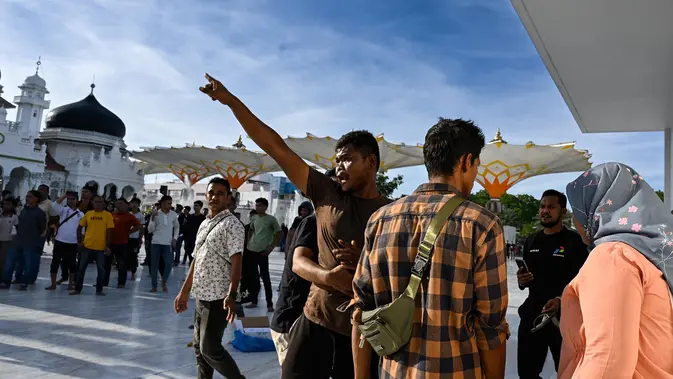 Peringatan 21 Tahun Perjanjian Damai Aceh Berujung Ricuh Para pengunjuk rasa yang marah meneriaki tentara saat mereka menurunkan bendera Gerakan Aceh Merdeka (GAM) yang dikibarkan berdampingan dengan bendera nasional Indonesia dalam sebuah unjuk rasa di Masjid Raya Baiturrahman, Banda Aceh, Sabtu, 15 September 2026. (AFP/ Chaideer Mahyuddin)