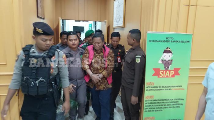 DIGIRING PETUGAS - Mantan Bupati Bangka Selatan, Justiar Noer dan mantan Camat Lepar, Dodi Kusumah ketika digiring menuju mobil tahanan Kejaksaan Negeri Bangka Selatan, Kamis (11/12/2025) malam. Keduanya resmi ditetapkan sebagai tersangka atas dugaan tindak pidana korupsi dengan kerugian mencapai Rp45,964 miliar.