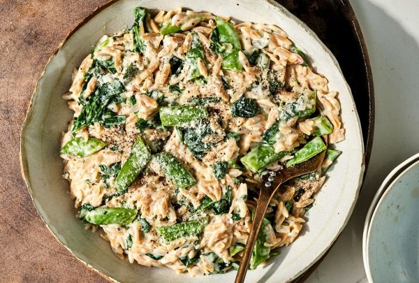 Overhead view of a plate of Creamy Lemon Orzo with Spinach & Snap Peas recipe Credit: Photographer: Jen Causey, Food Stylist: Ruth Blackburn