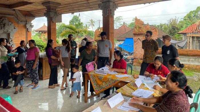 PANTAU - Penjabat Perbekel Desa Manukaya sedang memantau dan mengawasi pelaksanaan Posyandu di Banjar Malet.