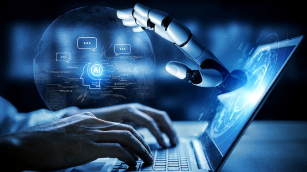 AI concept graphic showing robotic hand reaching out from laptop screen as human types on keyboard.