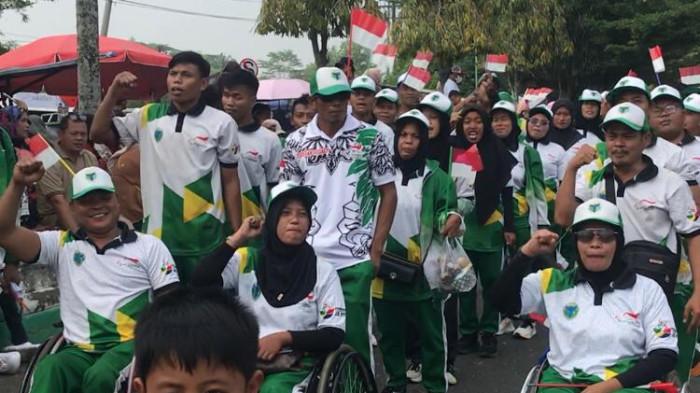 ATLET PARALIMPIK - Puluhan atlet paralimpik melintas saat Pawai HUT ke-81 RI di Batang Hari, Selasa (18/8). Mereka menyorakkan yel-yel.