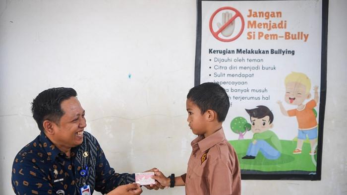 KARTU IDENTITAS ANAK - Camat Sebatik Tengah, Aris Nur, di sela perekaman KIA kepada anak-anak sekolah. Program jemput bola ini menjadi upaya mendekatkan pelayanan administrasi kependudukan kepada masyarakat. (TribunKaltara.com/Istimewa-Dokumentasi Kecamatan Sebatik Tengah)