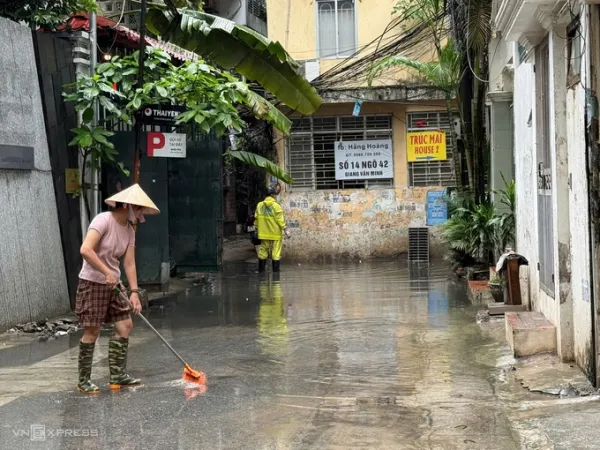 At 9:00 a.m. on July 28, alley 42 Giang Van Minh, Ba Dinh ward was still flooded more than 20 cm after two days of heavy rain, drainage workers had to be on duty to open the manhole cover to remove trash. Photo: Nga Thanh
