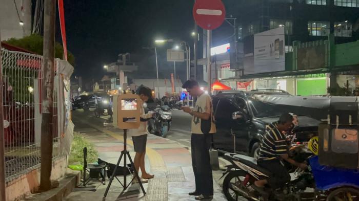 KREATIFITAS MAHASISWA - Foto Booth Outdor milik Wahyu Saputra (21) dan Susilawaty Idrus (21) mahasiswa UNG buka di kawasan Bundaran Saronde Kota Gorontalo, Rabu malam (19/8/2026). (Sumber Foto: TribunGorontalo.com/Jefri Potabuga)