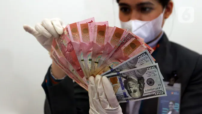 FOTO: Akhir Tahun, Nilai Tukar Rupiah Ditutup Menguat Karyawan menunjukkan uang rupiah dan dolar AS di Jakarta. (Liputan6.com/Johan Tallo)