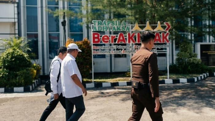 TIPIKOR -- Fikram Salilama tiba di Kantor Kejati Gorontalo, Jumat (21/8/2026), untuk memenuhi panggilan penyidik. Ketua KONI Gorontalo tersebut didampingi seorang pria yang disebut sebagai kuasa hukumnya saat memasuki gedung Kejati.
