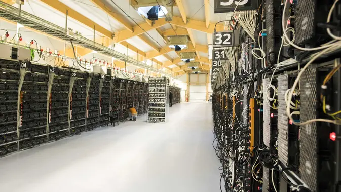 Seorang teknisi melakukan perawatan pada pertambangan dari komputer super di dalam pabrik bitcoin. (AFP Photo/Halldor Kolbeins)