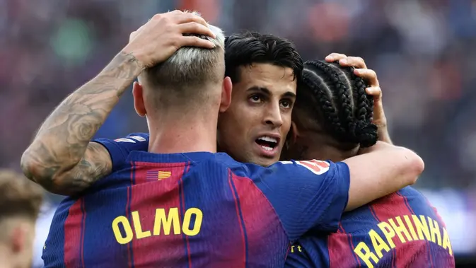 Bek Barcelona, Joao Cancelo, merayakan golnya bersama dua rekan setimnya, Dani Olmo dan Raphinha, ketika menghadapi Sevilla dalam lanjutan La Liga Spanyol di Camp Nou, Minggu (15/3/2026) malam WIB. (Lluis GENE / AFP)