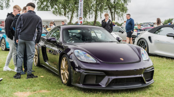A purple Porsche Cayman GT4 parked on a car meet.