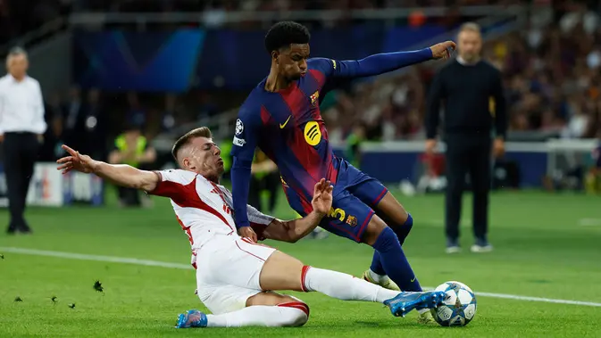 Pemain Olympiakos, Costinha (bawah), berusaha menghentikan pemain Barcelona, Alejandro Balde, dalam pertandingan fase pembuka Liga Champions antara Barcelona dan Olympiakos di Barcelona, Spanyol, Selasa, 21 Oktober 2025. (AP Photo/Joan Monfort)   