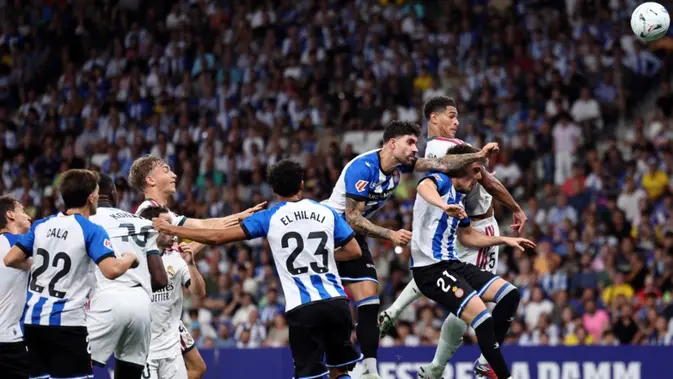 Gelandang asal Inggris milik Real Madrid, Jude Bellingham (kanan), menyundul bola dalam pertandingan Liga Spanyol antara RCD Espanyol dan Real Madrid CF di Stadion RCDE, Cornella de Llobregat, pada 23 Agustus 2026. (Josep LAGO/AFP)